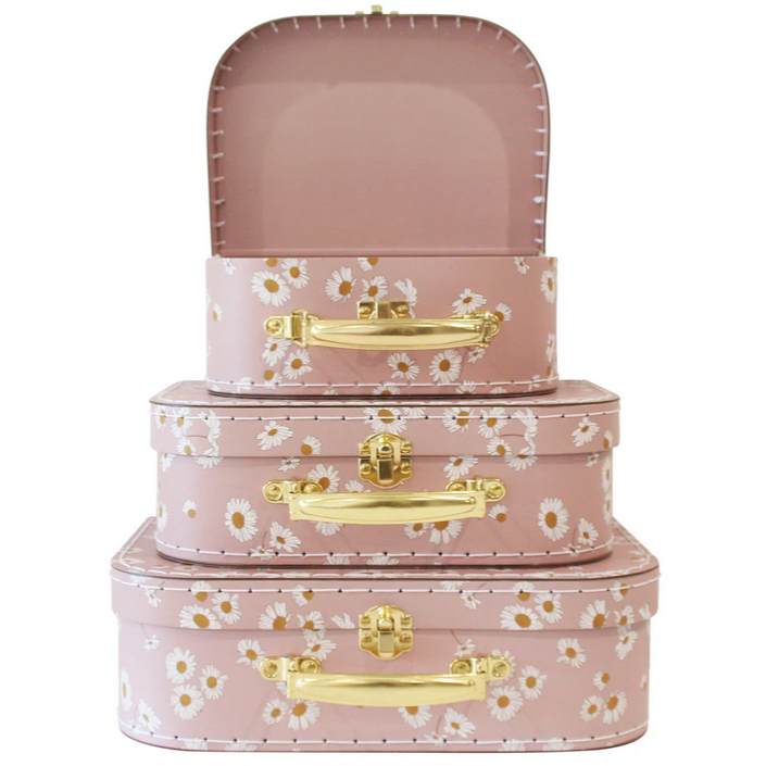 Set of three pink floral-patterned suitcases with gold handles on a white background