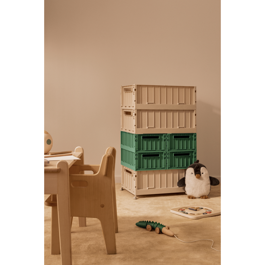 Children's room with wooden furniture, stacked crates, and toys on a beige floor.
