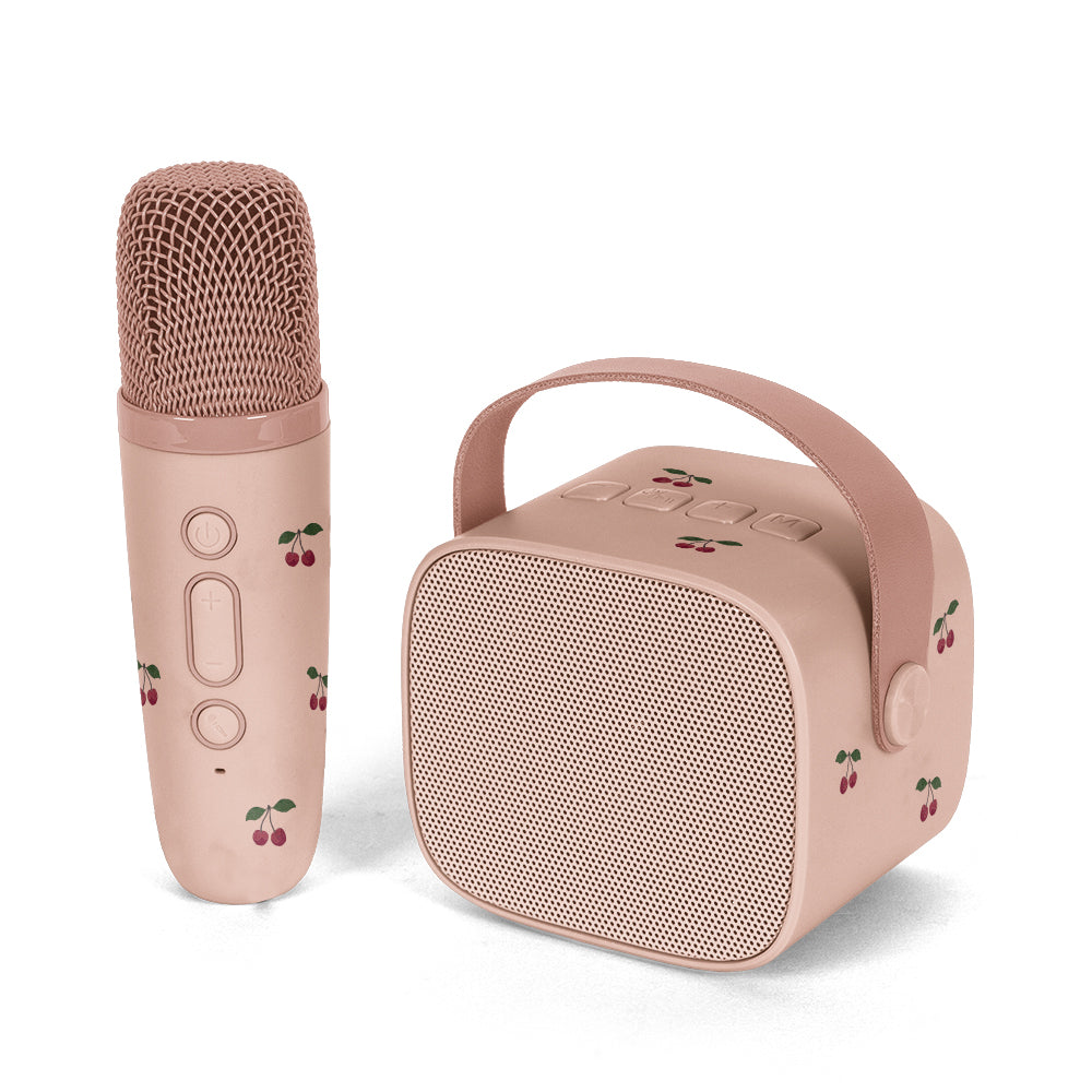 A pink portable karaoke microphone and matching speaker set with cherry illustrations, shown on a clean white background.