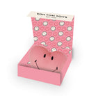 A pink plush smiley face toy partially tucked inside a pink gift box with a repeating smiley face pattern on the inside lid. The top flap shows the brand name 'BON TON TOYS EST.
