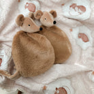 Two plush mouse toys on a soft, patterned blanket