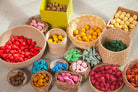Colorful wooden grapat mandala toys in woven baskets on a textured surface