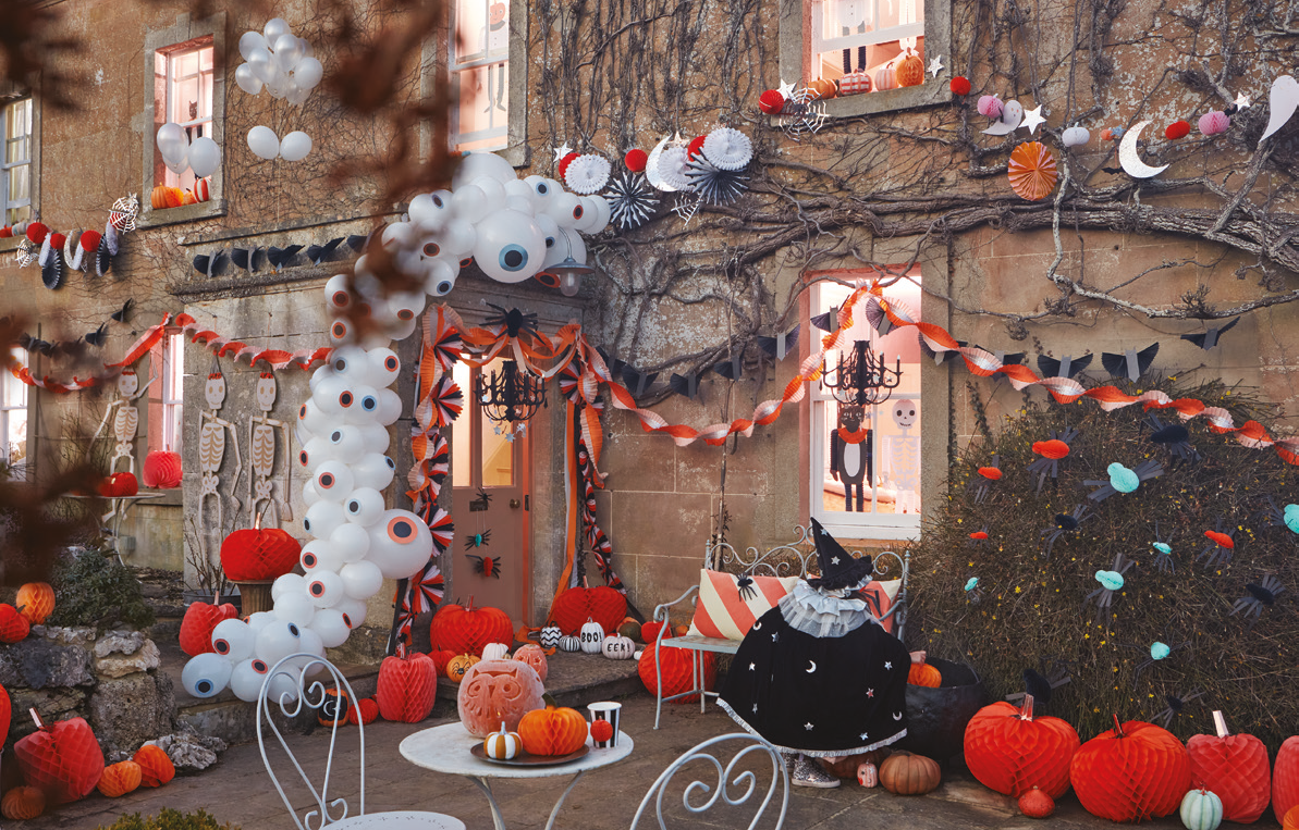 Halloween-themed outdoor setting with decorations, pumpkins, and a cat.