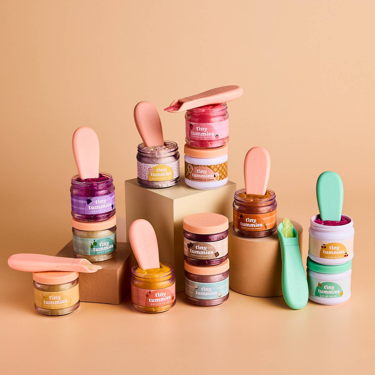 Colorful doll food jars with spoons on a beige background