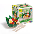 Wooden salad bowl set with toy vegetables and utensils in front of its packaging.
