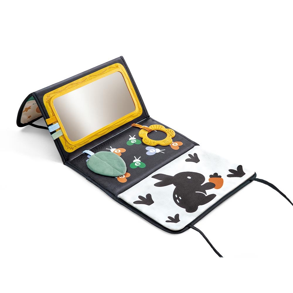 Children's activity book with mirror, rattle, and stickers on a white background
