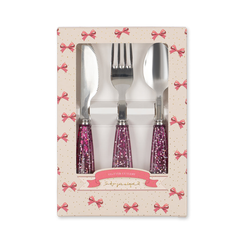 Set of cutlery with purple handles in a decorative box on a white background