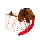 Plush dog toy with a red bone inside a polka dot bag on a white background