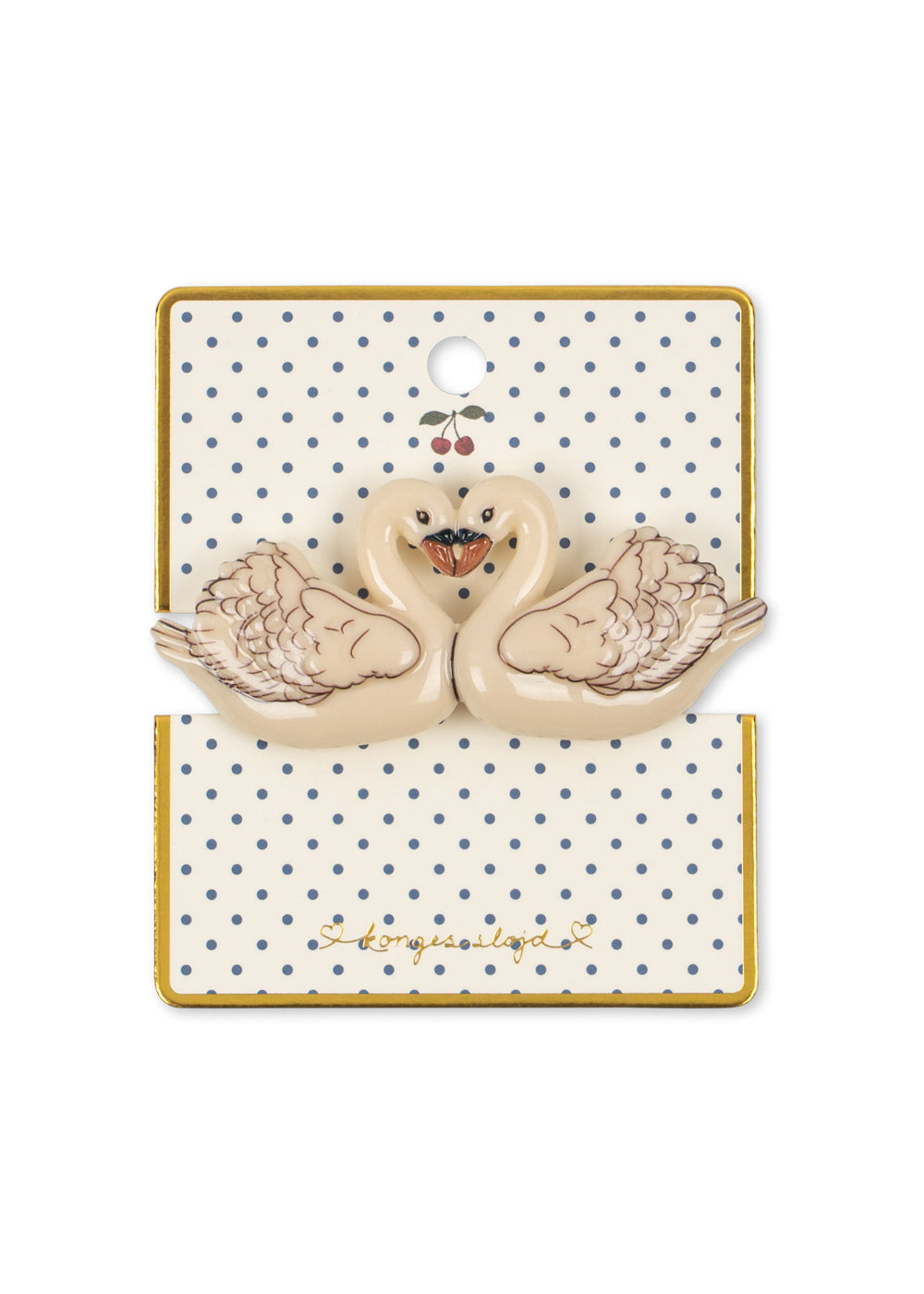 A  swan-shaped konges slojd hair clip displayed on a branded backing card. The hair clips are cream-colored with brown feather detailing and a small orange beak, attached to a cream card with blue polka dots and a gold border.