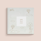 A beige baby record book with gold foil details and illustrations of a baby, balloons, and clouds on the cover. The title 'your first years' is displayed.