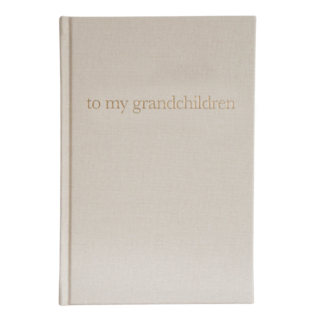 A linen-covered journal with gold-foil printing, titled 'to my grandchildren' on the cover.